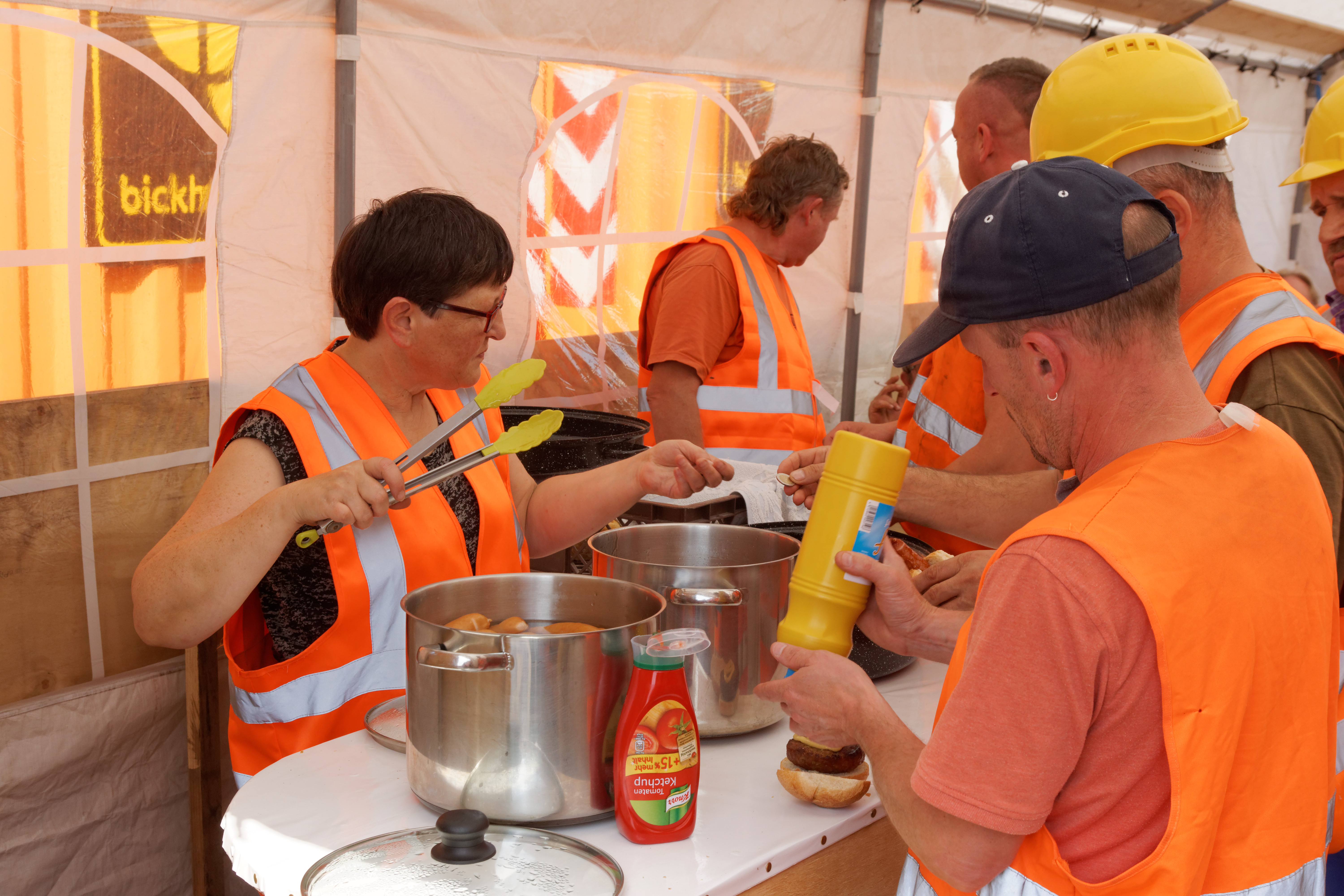 High-Noon im Baucamp – Kantinenchefin Sigrid versorgt die Hungrigen mit Brötchen, Bockwurst, Buletten und Kaffee.